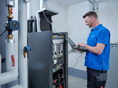 Servicetechniker bei der Wartung einer Anlage mit Laptop – spannende Karrieremöglichkeit im technischen Außendienst