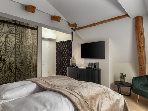 Leise arbeitendes Fancoil im Dachgeschosszimmer des Boutique Hotel Maier, unauffällig integriert für komfortables Heizen und Kühlen im historischen Bestand.