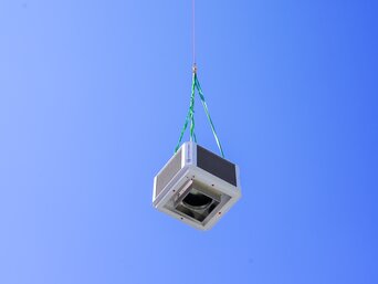 Helikopter hebt Anlagenteile zur ENGEL-Produktionshalle für die Installation des Sustainable Hall Conditioning Systems von bösch und INFRANORM®