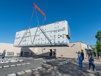Sieben Tonnen wiegt das wetterfeste Gerät für Umkleide und Nebenräume, welches per Auslegerkran vom 50 Meter entfernten Parkplatz auf das Dach gehievt wurde. | © bösch heizung.klima.lüftung