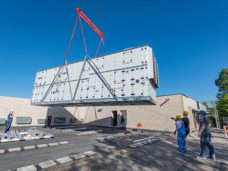 Sieben Tonnen wiegt das wetterfeste Gerät für Umkleide und Nebenräume, welches per Auslegerkran vom 50 Meter entfernten Parkplatz auf das Dach gehievt wurde. | © bösch heizung.klima.lüftung