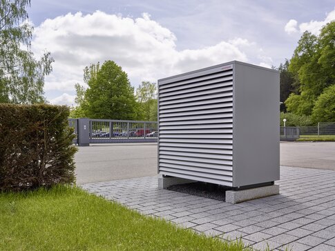 Modulierende Luft/Wasser-Wärmepumpe BIBLOCK mit Splitbauweise von bösch auf Ziegeln neben Grasfläche