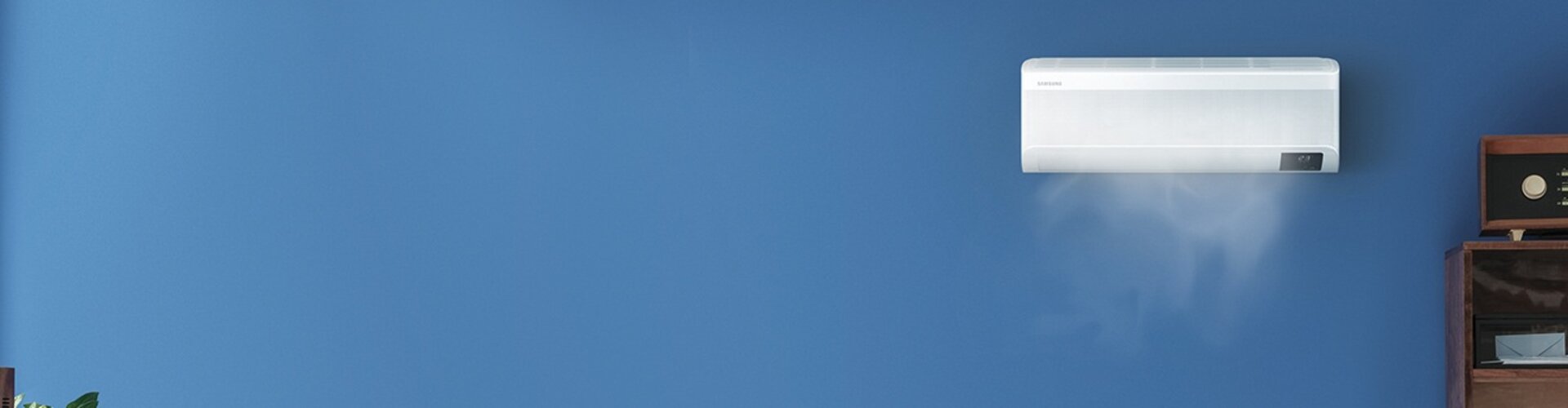 Samsung Klimagerät an der Wand in einem modernen Raum mit blauer Wandfarbe. Sanfte Luftströmung wird visualisiert, die die Klimatisierung des Raums unterstützt | © Samsung