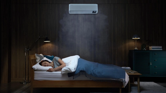 Eine Person schläft in einem Schlafzimmer, während ein Samsung Klimagerät über dem Bett für angenehme Raumtemperatur sorgt. Sanfte Luftströmung ist visualisiert | © Samsung